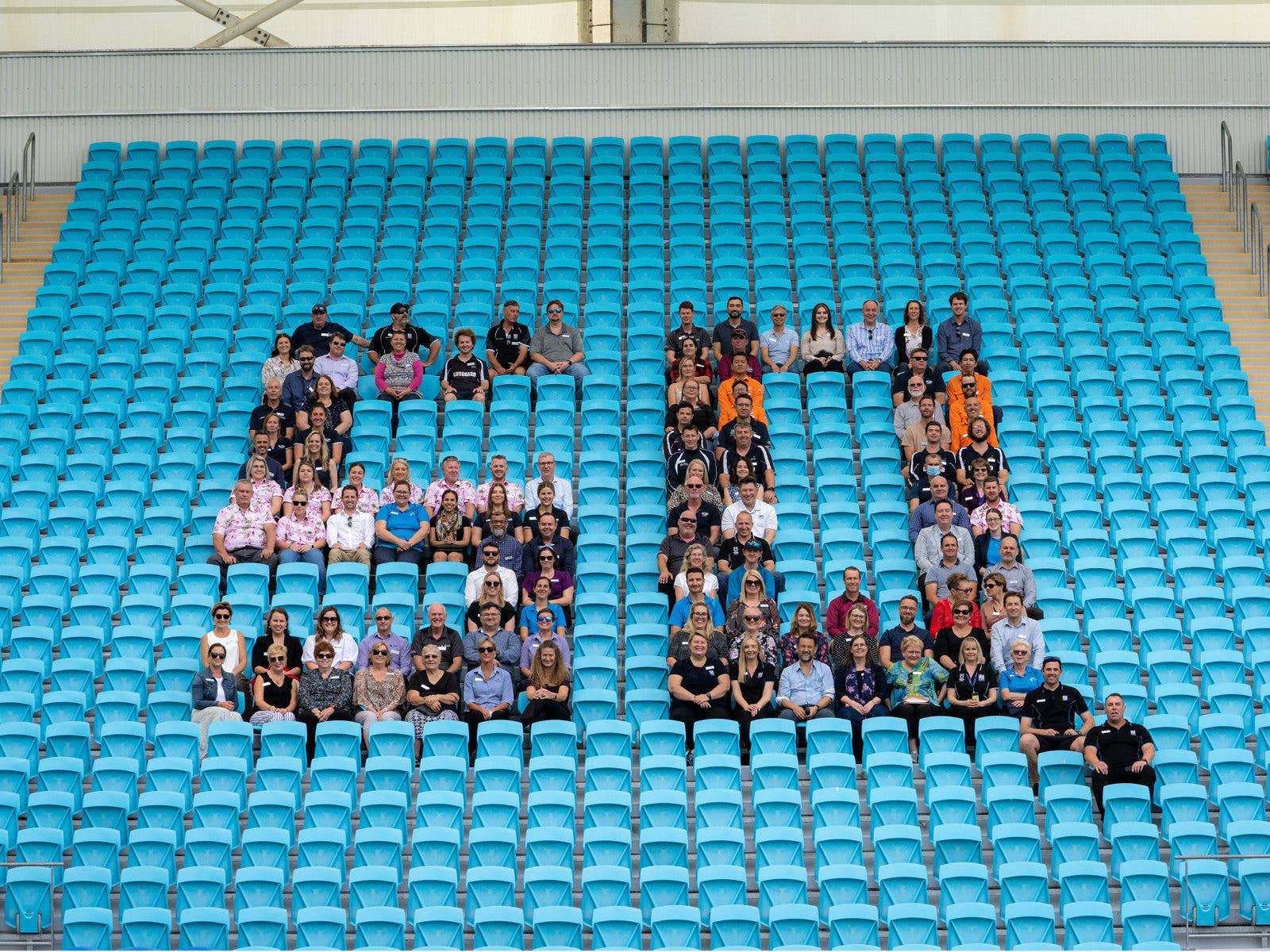 The Stadiums Queensland staff sit in the seating bank forming the shape of SQ with their positions