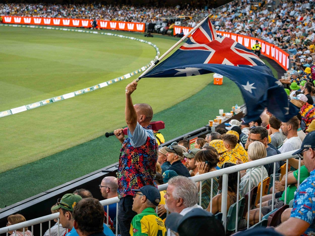 A man in the field waves the Australian flag at The Gabba